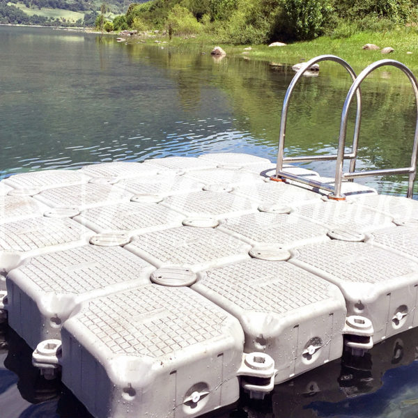 Vista amplia de una balsa de muelles flotantes gris con escalera