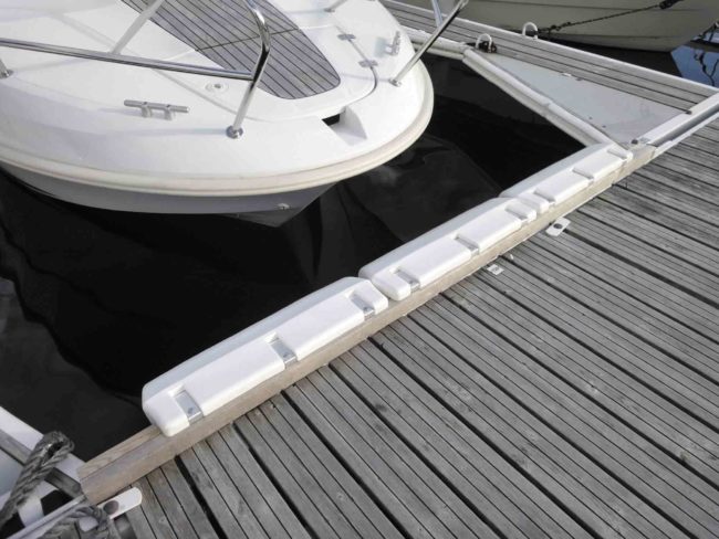 Parte delantera de un bote junto al muelle de madera