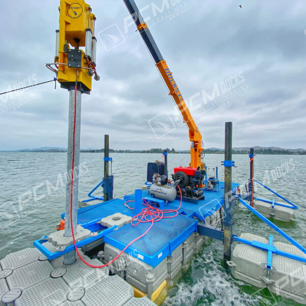 Grúa naranja sobre muelle flotante