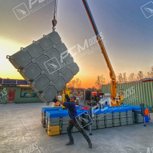 Grúa flotante naranja en plataforma sobre el agua